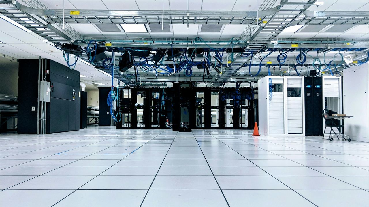 Data hall with equipment cabinets beneath overhead cable trays