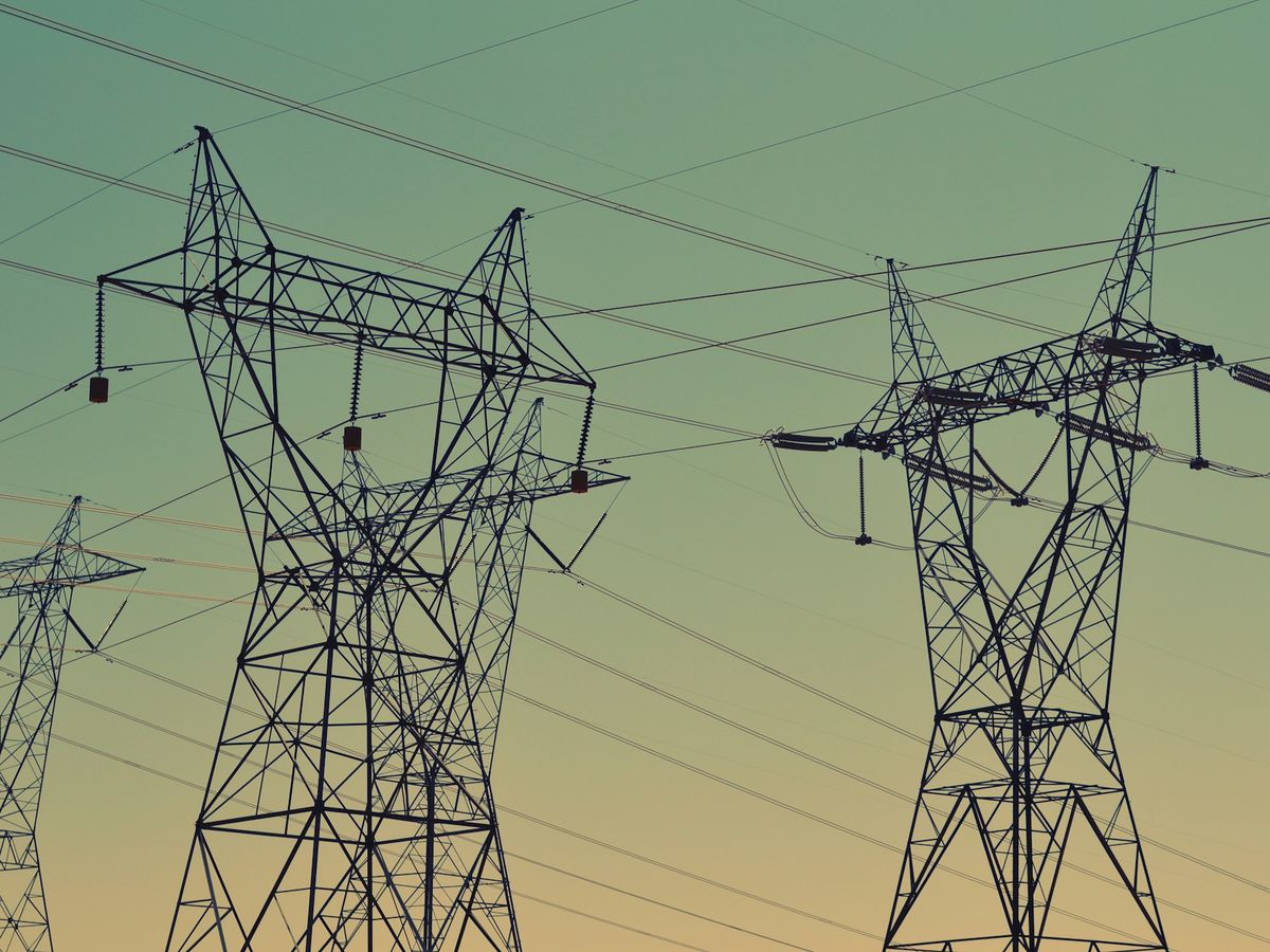 High-voltage transmission towers and lines against an evening sky